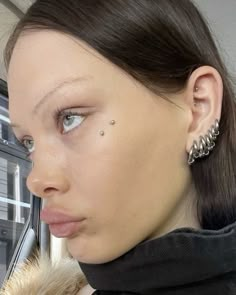 a woman with piercings on her nose looking at the camera