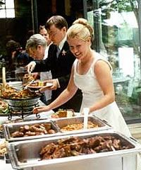 a woman in a white dress is serving food to people at a buffet line up