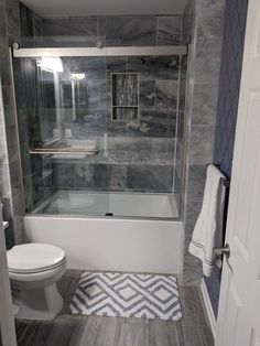 a white toilet sitting next to a walk in shower