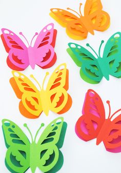 colorful butterfly cut outs sitting on top of a white table