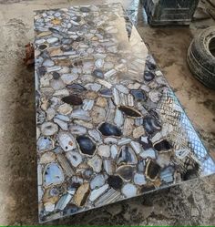 a table that has some kind of design on it in the middle of dirt and rocks