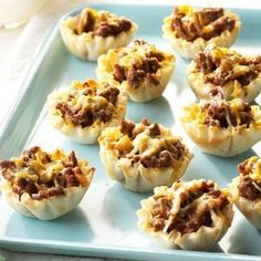 small appetizers with meat and cheese are on a blue tray, ready to be eaten