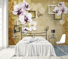 the bedroom is decorated with white and purple orchids on the wall, along with an iron bed