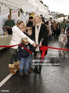 a woman and two children are holding onto a ribbon as they walk down the street