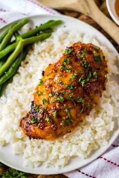 a white plate topped with rice and chicken next to green beans