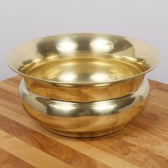 two metal bowls sitting on top of a wooden table