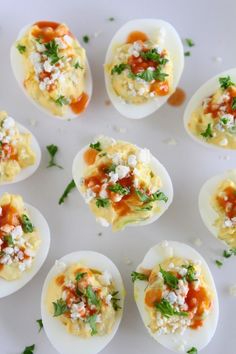 deviled eggs topped with cheese and garnished with parsley