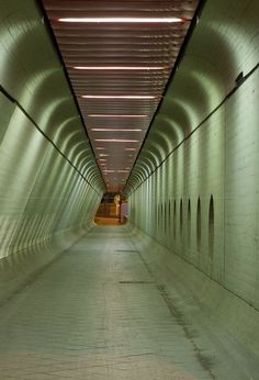 an empty tunnel with lights on either side and no people in the area at all