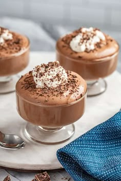 three small desserts with whipped cream and chocolate