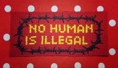 a red and white polka dot table cloth with the words no human is illegal on it