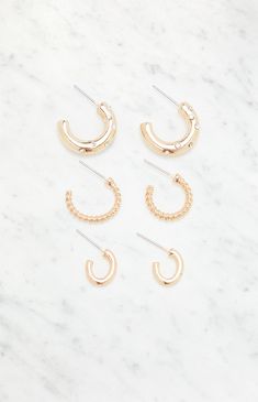 Elevate your accessory game with the 3 Pack Dainty Hoop Earrings from LA Hearts. This set features a variety of hoop designs, including braided and rhinestone-studded styles, offering versatility and a touch of glamour to your everyday looks.


	Includes 3 pairs of hoop earrings
	Post back closure
	Gold finish Aesthetic Earrings Gold, Small Hoops Earrings, Dainty Hoop Earrings, Hoops Earrings, Hypoallergenic Earrings, Women Accessories Jewelry, Pacsun, The 3, Gold Finish