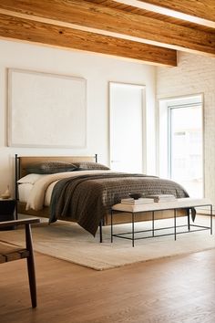 a bed sitting in a bedroom on top of a wooden floor next to a window