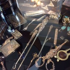 an assortment of silver items on display in a glass case