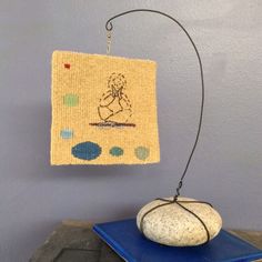 a rock sitting on top of a blue table next to a piece of cloth hanging from a hook