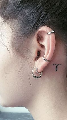 a woman's ear with two small hoops on the back of her left ear