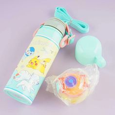 a blue water bottle next to an orange and yellow toy on a purple surface with other items