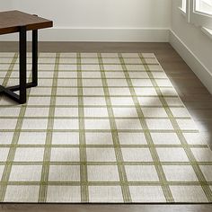 an area rug with a wooden table and window in the background