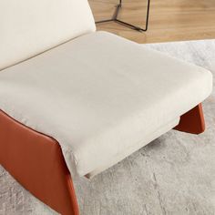 a white and brown chair sitting on top of a rug