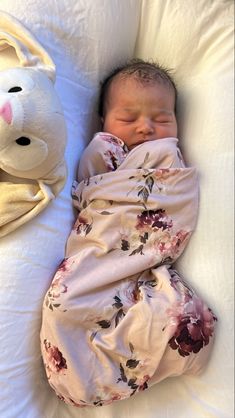 a baby is sleeping next to a stuffed animal