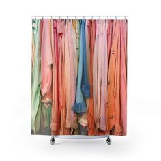 a shower curtain with colorful clothes hanging on it's sides and the bottom half open