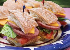 two sandwiches with cheese, lettuce and tomato on them are sitting on a plate