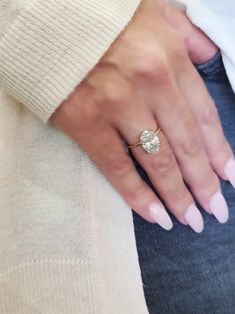 a close up of a person's hand with a ring on their finger and a sweater