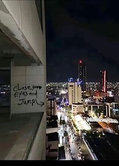 graffiti on the side of a building in front of a cityscape at night