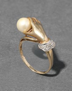 "Find ALEXIS BITTAR Vintage 1940s 14k Hand Ring Motif Ring With Cultured Pearl & Diamond on Editorialist. Details From the decadent early 1940s, this stunning Victorian inspired 14k gold ring has the detailed silhouette of a hand holding a cultured pearl with a silver tone ruffled sleeve accented with diamonds. For further details, additional photos or a private consultation on this style, please contact service@alexisbittar. com. 14k gold, pearl, diamond UPC: 990100071041 Measurements .375\" north/south Care To clean, gently wipe the surface with a soft cloth. For additional care instructions visit our FAQ page. | Vintage 1940S 14K Gold Hand Ring Motif Ring With Cultured Pearl & Diamond in Gold/Silver Size 6 by Alexis Bittar" Vintage White Pearl Ring, Pearl Rings In Gold Vintage, Vintage Adjustable Pearl Ring For Wedding, Vintage 14k Gold Pearl Ring, Gold Hand Ring, Luxury Vintage Pearl Ring, Dainty Wedding Ring, Pearl And Diamond Ring, Hand Ring