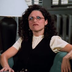 a woman with glasses sitting in a chair