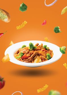 a plate of food with broccoli, carrots and other vegetables flying around