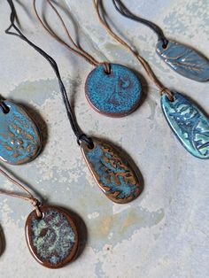 six necklaces with different designs on them