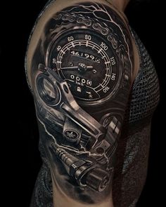 a man's arm with a tattoo on it that has a speedometer and wrench