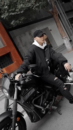 a man sitting on top of a black motorcycle