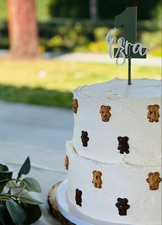 a white cake with brown teddy bears on it and a green sign that says grra