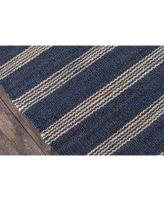 a blue and white striped rug on top of a wooden floor next to a door