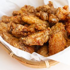 a basket filled with fried chicken sitting on top of a table