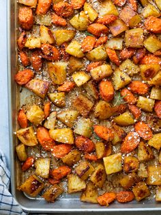 roasted potatoes and carrots with parmesan sprinkles in a baking pan