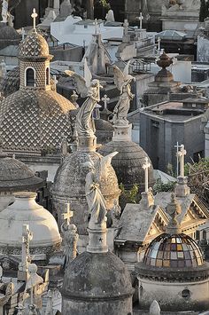 an aerial view of many cemetery headstones with statues and crosses in the middle one is black and white