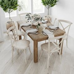 a wooden table with white chairs and flowers on it