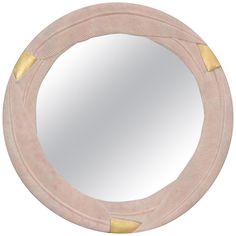 a round mirror with gold accents on the edges and an oval shape in the middle