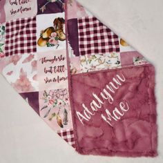 a close up of a pink and white patchwork quilt with words written on it