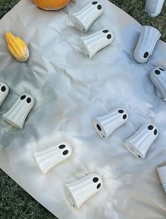 halloween decorations made to look like ghost heads on a sheet of paper with pumpkins in the background