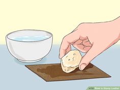 a person is peeling an object from a table with a bowl of water in the background