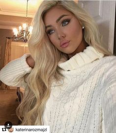 a woman with long blonde hair wearing a white sweater