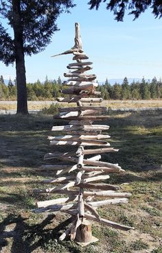 a tree made out of logs sitting in the grass