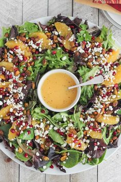 a salad with dressing in a bowl on a white plate next to an orange slice