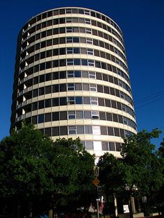 a tall building with lots of windows next to trees