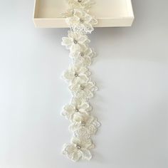 a white tray with flowers on it and a chain hanging from the wall behind it