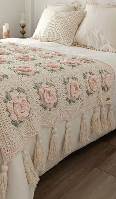 a crocheted bed with pink roses on it