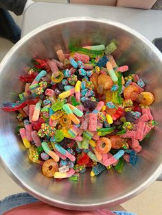 a metal bowl filled with lots of colorful candy